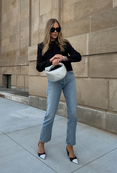 A black top, blue denim and a light handbag